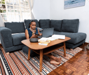 lady sitting on a MoKo Jiji sofa back cushion and working on her laptop